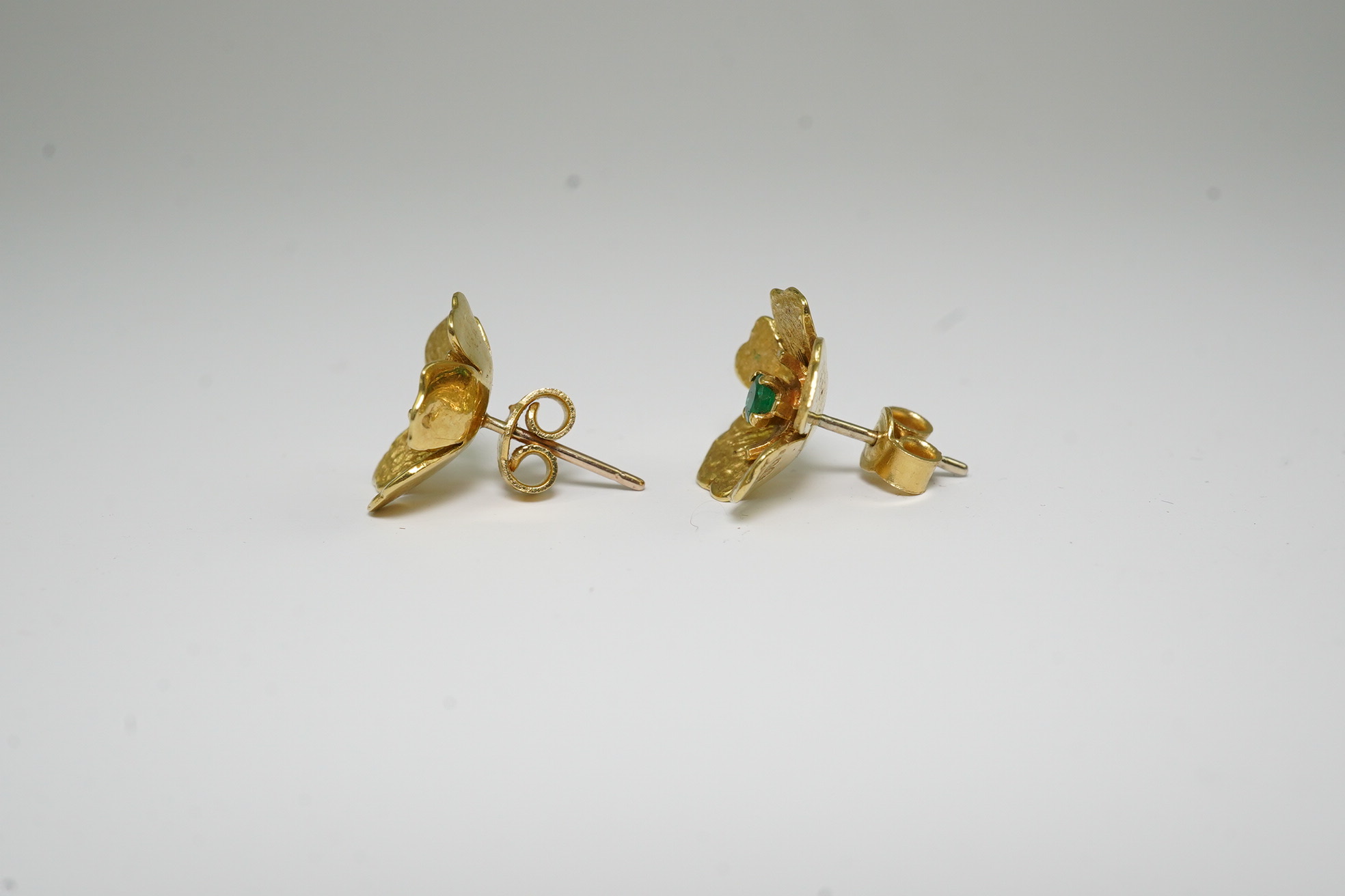 A pair of 1970's 18ct gold and single stone emerald set flower head earrings